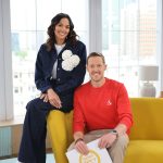 a man and woman sitting on a yellow couch