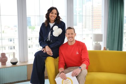 a man and woman sitting on a yellow couch